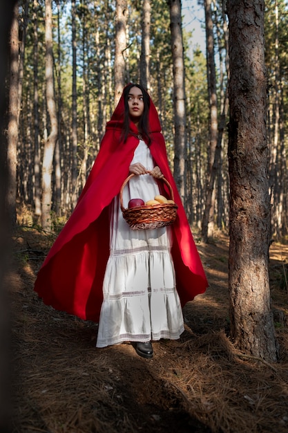 Foto grátis chapeuzinho vermelho com cesto de madeira com guloseimas