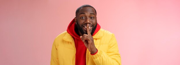 Charmoso jovem afro-americano feliz homem barbudo em casaco amarelo capuz vermelho preparar lindo aniversário