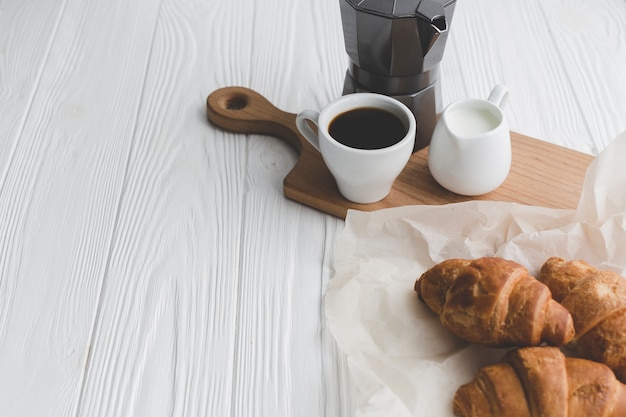 Chávena de café perto de croissants