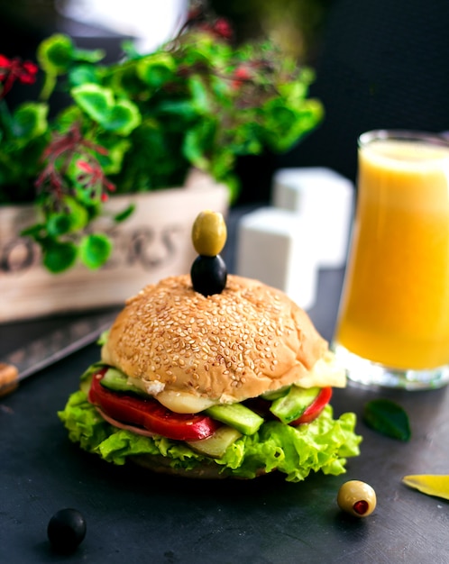 Cheeseburger com azeitonas por cima e suco