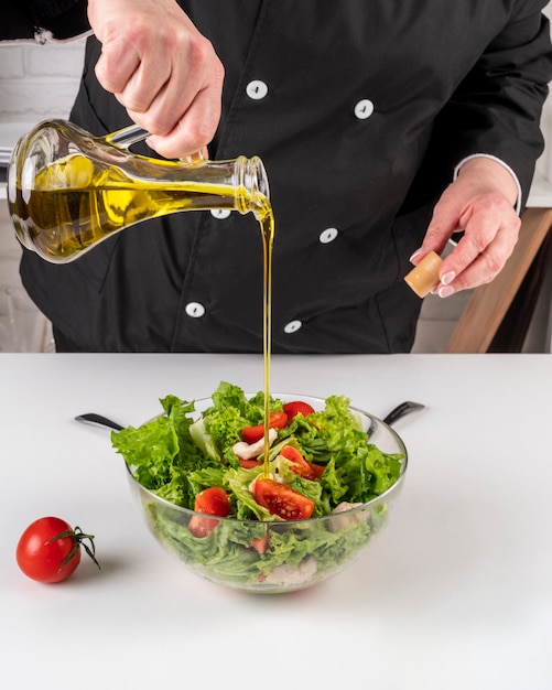 Foto grátis chef, adicionando óleo à salada