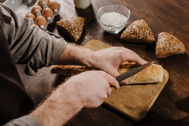 Chef alto cortando pão