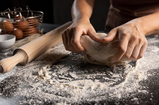 Foto grátis chef amassando a massa na farinha na mesa