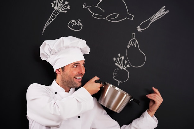 Foto grátis chef bonito pegando ingredientes para a sopa