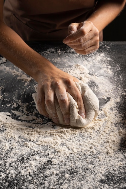 Foto grátis chef cobrindo a massa com farinha para torná-la menos pegajosa