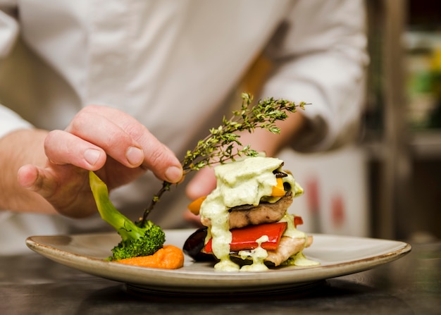 Chef colocando ervas na refeição gourmet