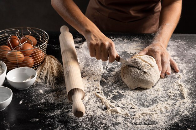 Chef cortando massa de pão na mesa