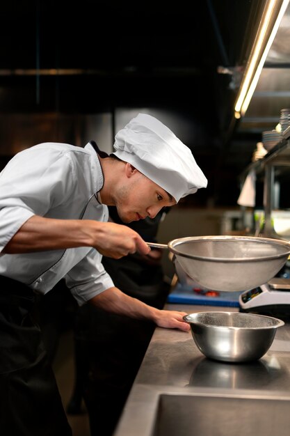 Chef cozinhando na cozinha vestindo roupas profissionais