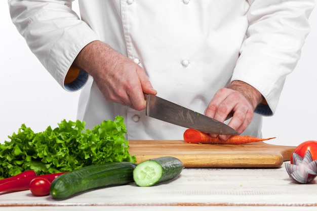 Chef de cozinha salada de legumes frescos em sua cozinha