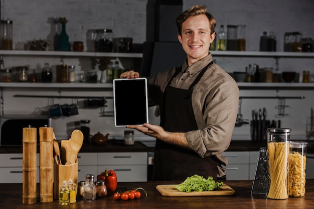 Chef de meio de tiro mostrando um tablet em branco