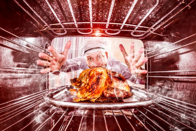 Chef engraçado negligenciou frango assado no forno, então ela tinha queimado, vista de dentro do forno. cook perplexo e com raiva. perdedor é o destino!