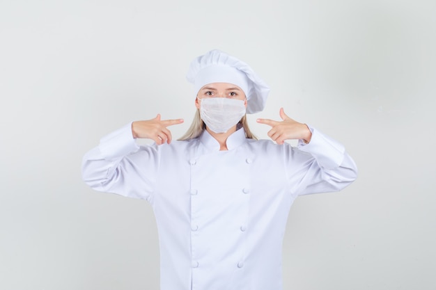 Foto grátis chef feminina de uniforme branco apontando o dedo para a máscara médica