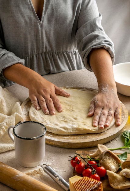 Chef feminina esticando massa de pizza