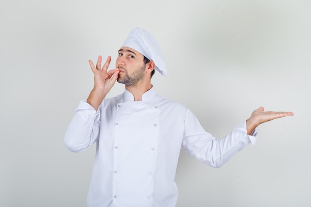 Chef masculino fazendo um gesto delicioso em uniforme branco