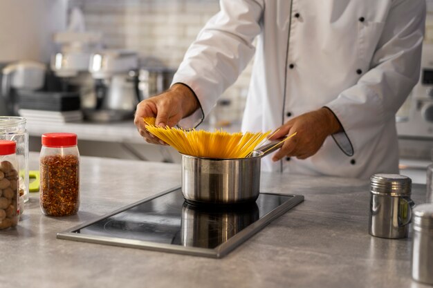 Chef masculino na cozinha fervendo macarrão