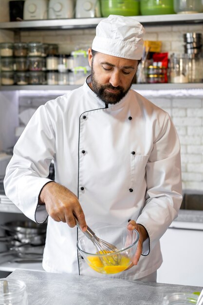 Chef masculino na cozinha usando ovos para cozinhar