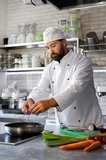 Chef masculino no prato de cozinha em uma frigideira