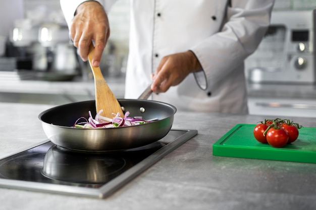 Chef masculino no prato de cozinha em uma frigideira