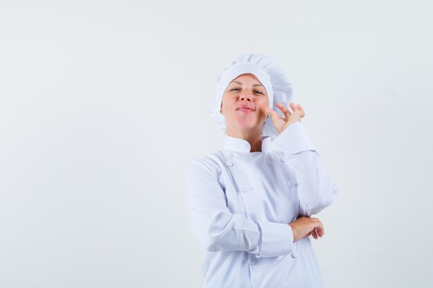 chef mulher de uniforme branco mostrando gesto zip e procurando espaço garantido para texto