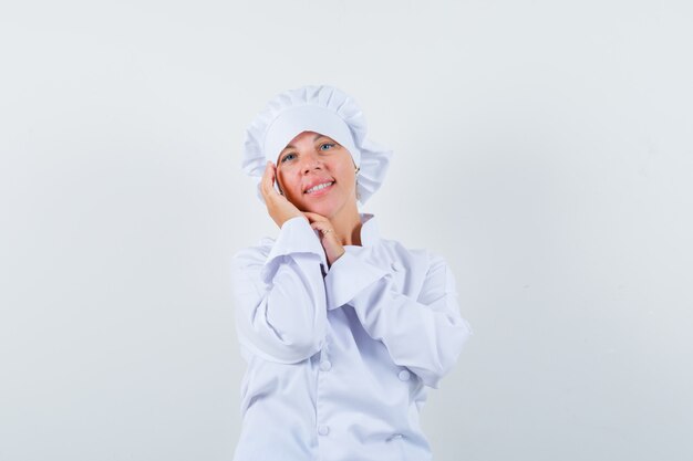 chef mulher tocando a pele do rosto na bochecha em uniforme branco e elegante.