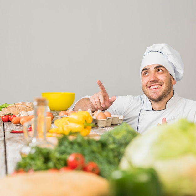 Foto grátis chef na cozinha apontando para copyspace