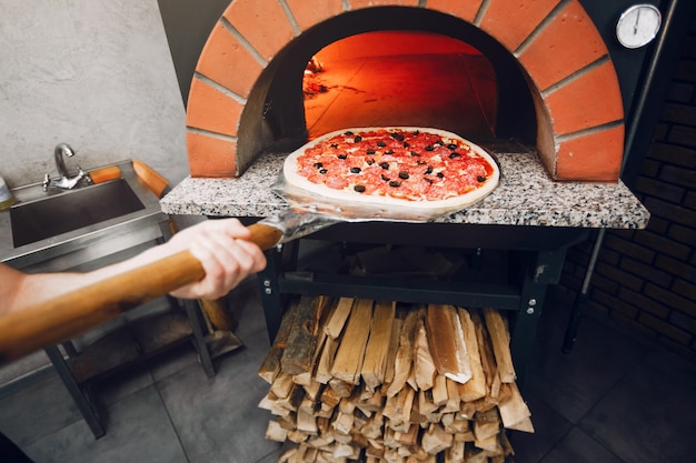 Chef na cozinha prepara pizza