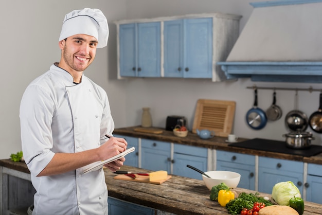 Foto grátis chef na cozinha tomando notas