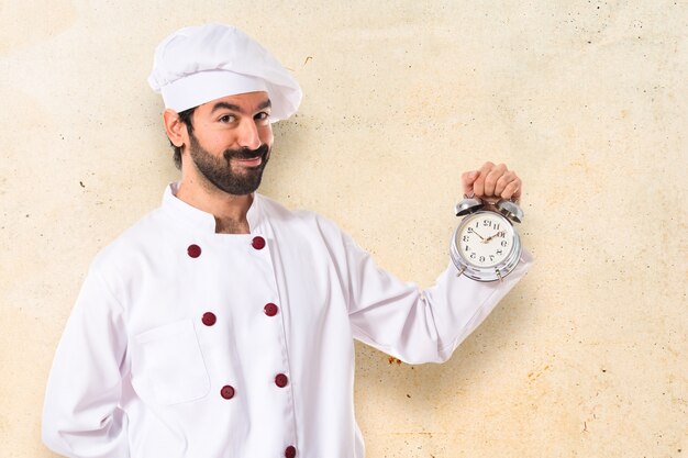 Chef segurando um relógio sobre fundo branco