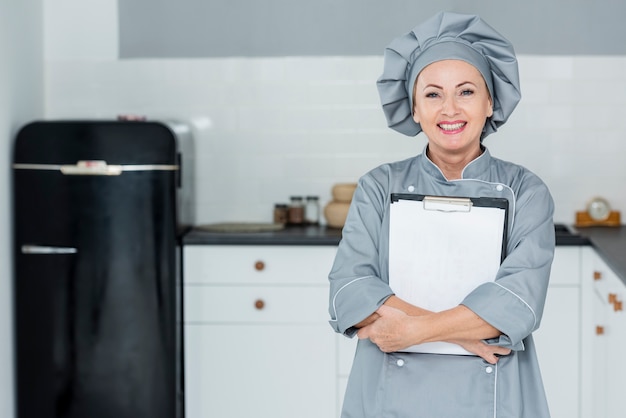 Foto grátis chef sorridente com prancheta