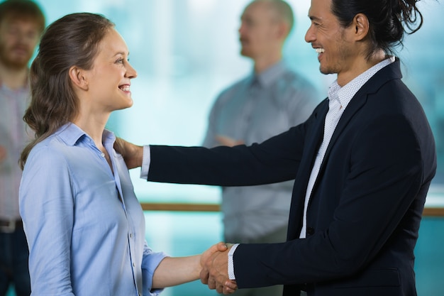 Chefe alegre felicitando novo funcionário