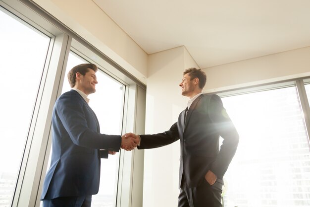 Chefe, apertando a mão e agradecendo o trabalhador pelo bom trabalho