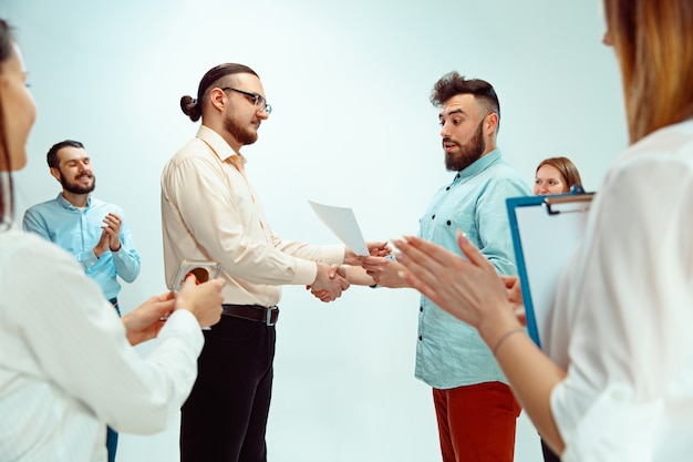 Chefe aprovando e parabenizando jovem funcionário de sucesso