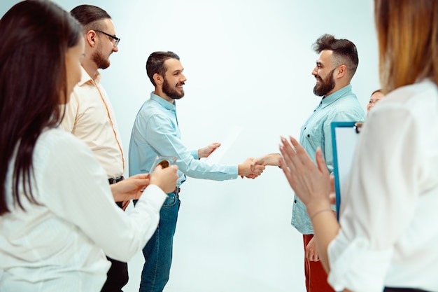 Chefe aprovando e parabenizando jovem funcionário de sucesso