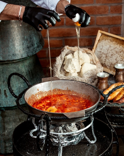 Chefe derrama ovos na omelete de tomate