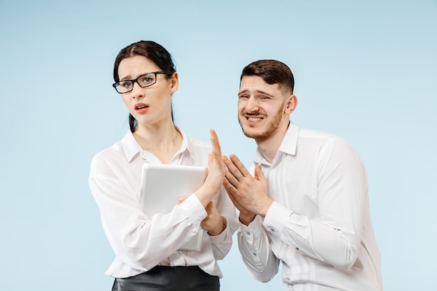 Chefe zangado. mulher e sua secretária em pé no escritório ou estúdio. empresário gritando com seu colega. modelos caucasianos femininos e masculinos. conceito de relacionamento no escritório, emoções humanas