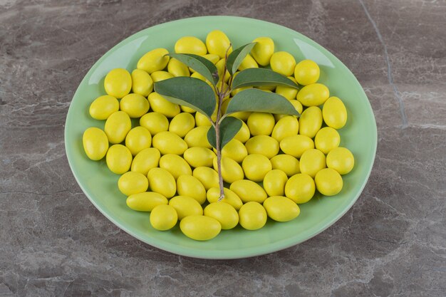 Chiclete de menta amarelo no prato na superfície do mármore