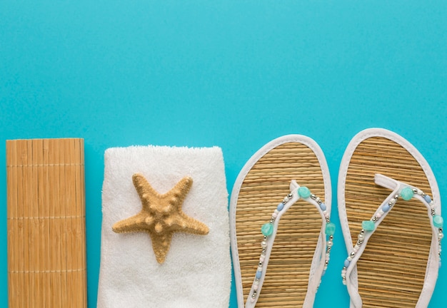 Foto grátis chinelos de verão vista superior com toalha e estrela do mar