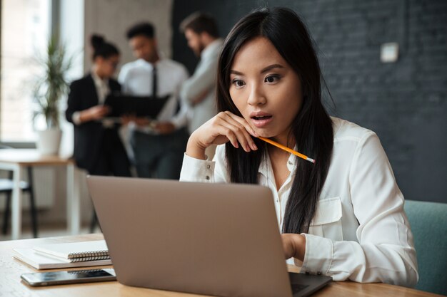 Chocado jovem empresária asiática