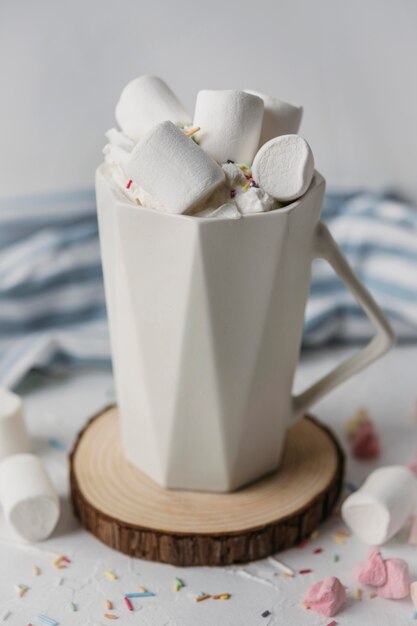 Chocolate quente de ângulo alto com marshmallows na caneca
