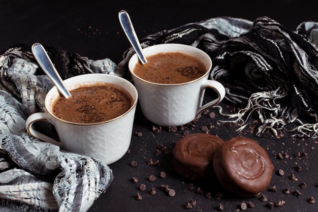 Chocolate quente em xícaras com biscoitos