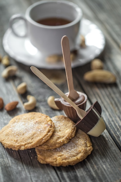 Foto grátis chocolates, biscoitos e nozes em superfície de madeira