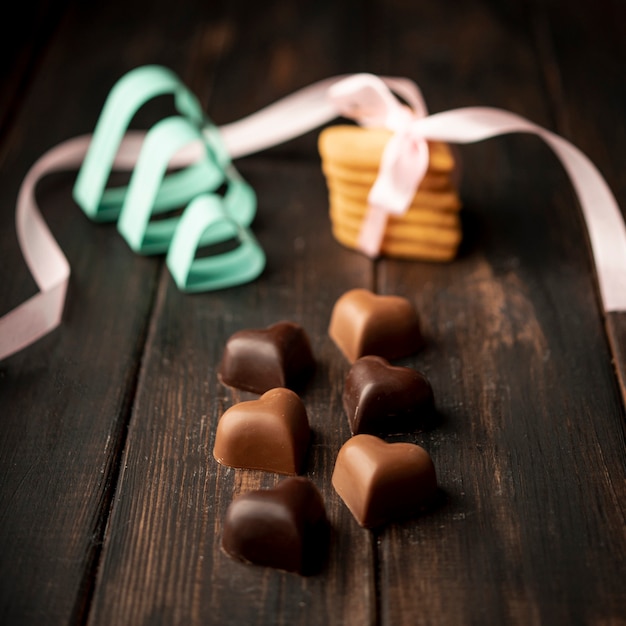 Foto grátis chocolates em forma de coração com biscoitos e fita