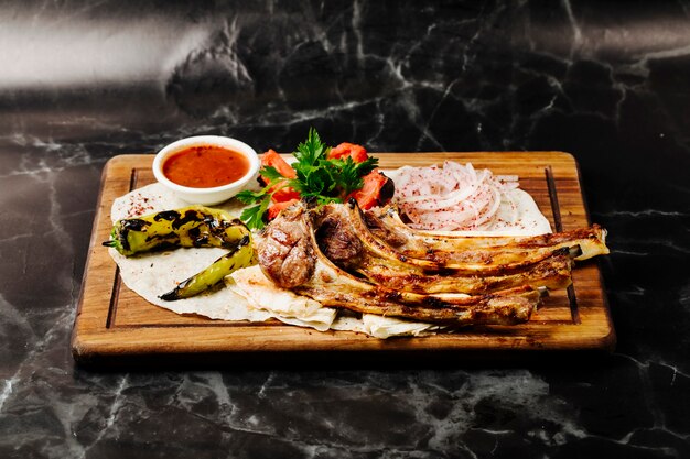 Churrasco de osso de carne em lavash com legumes grelhados e molho vermelho.