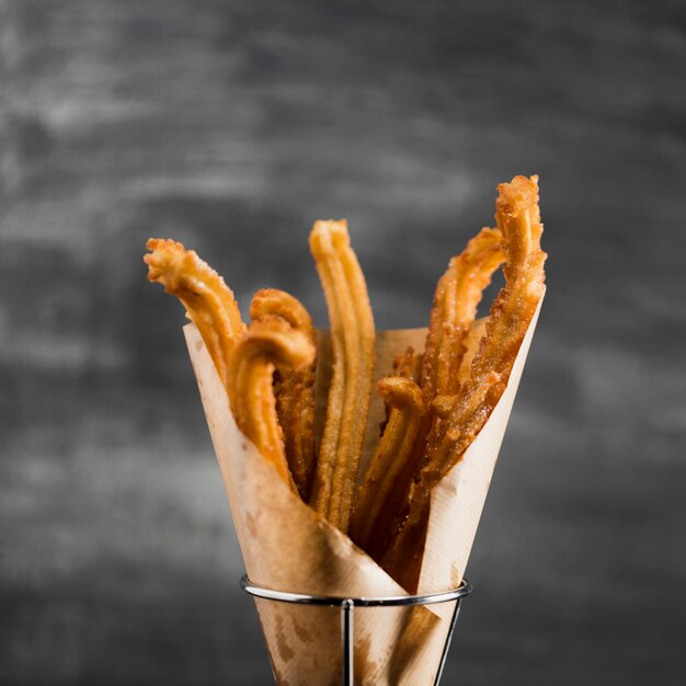 Churros de close-up em um copo com fundo desfocado