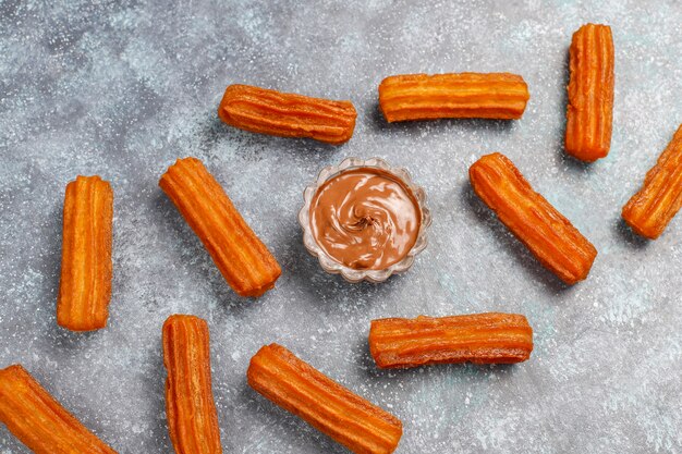 Churros de sobremesa mexicana tradicional com chocolate, vista superior