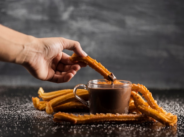 Churros deliciosos com chocolate derretido na mesa