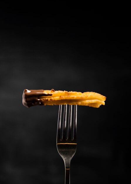 Churros fritos minimalistas em um garfo vista frontal