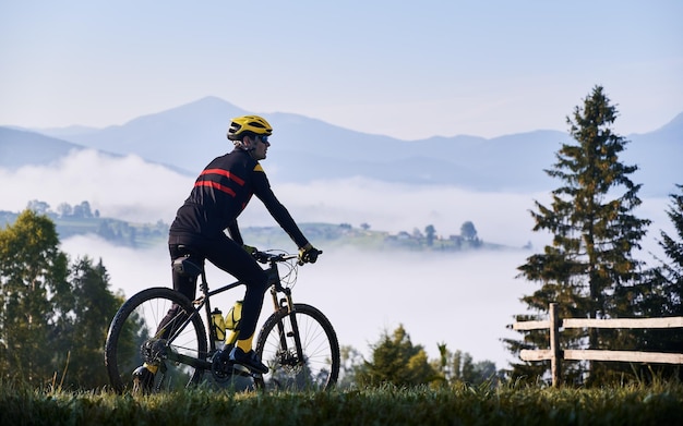 Ciclista masculina andando de bicicleta nas montanhas