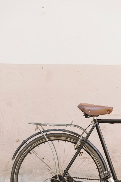 Ciclo velho estacionado perto de muro de concreto