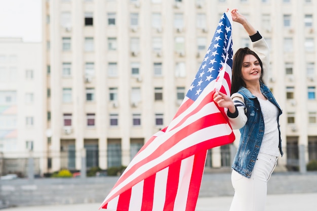 Cidadão americano feminino orgulhoso com bandeira desdobrada